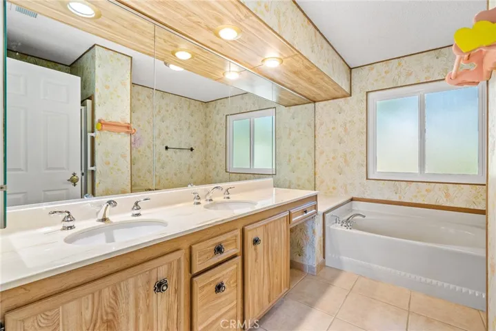 The primary suite bathroom boasts a large dual sink vanity, soaking tub and separate shower.