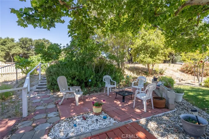 Cozy brick patio area that is a great pot for either a firepit or maybe a conversation set so you can enjoy the shade of the mature tree.