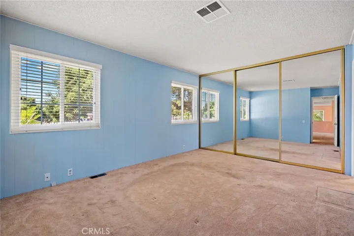 The primary bedroom is at the end of the hallway and has a huge closet with mirrored doors.