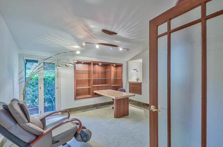Bedroom configured as office with built-in shelves and table