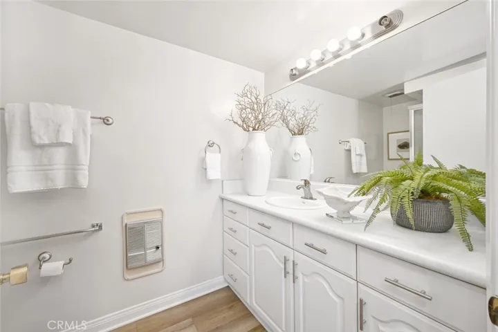 Remodeled bathroom with solid counters and full wall mirror.