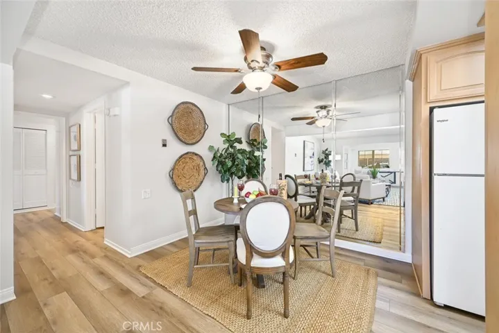Dining room with ceiling fan and mirrored wall.