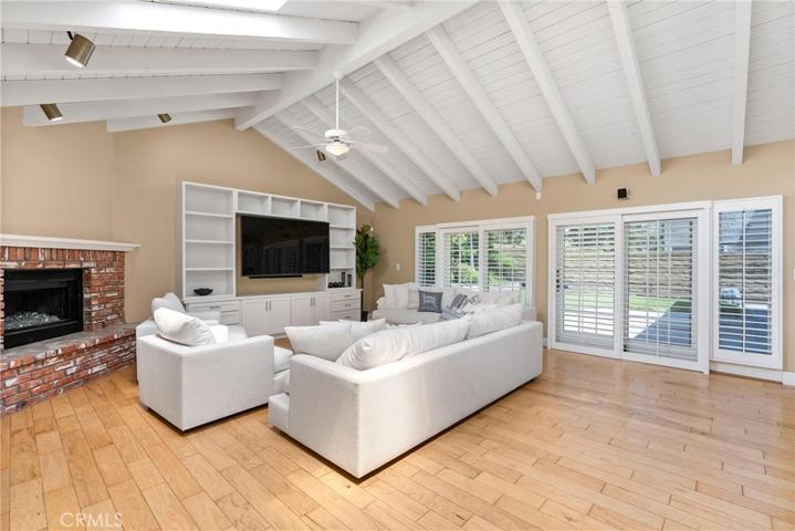 Completely open to the kitchen is a massive living room with a gas fireplace, 2 sliding doors to the backyard, vaulted ceilings and two skylights!