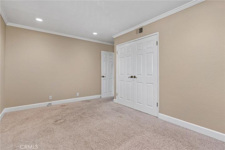 Large secondary bedrooms with recessed lights and crown molding.