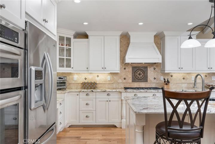 Top-of-the-line appliances including a 5-burner gas cooktop with a vented hood, a dishwasher and a built-in double oven with a warming drawer!