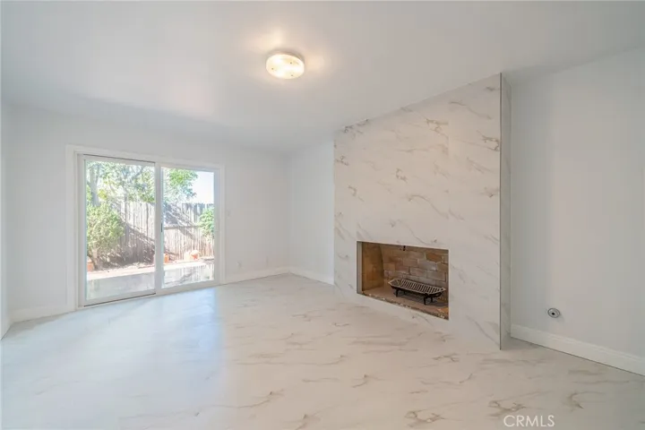 Downstairs bedroom #2 with fireplace and sliding door to the backyard patio and garden.