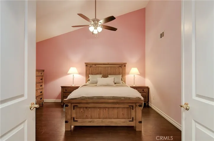 Double door master bedroom suite with vaulted ceilings and ceiling fan