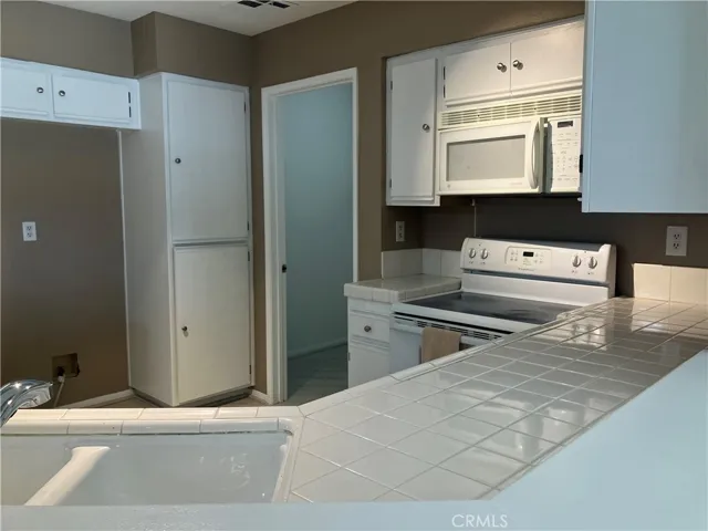 Kitchen tile countertop and entryway to laundry room.