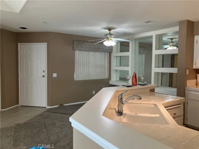 Open and airy plan; entryway, eating area, kitchen countertop and sink.