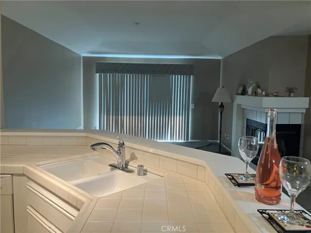 Kitchen view of open floor plan facing into living room and corner fireplace