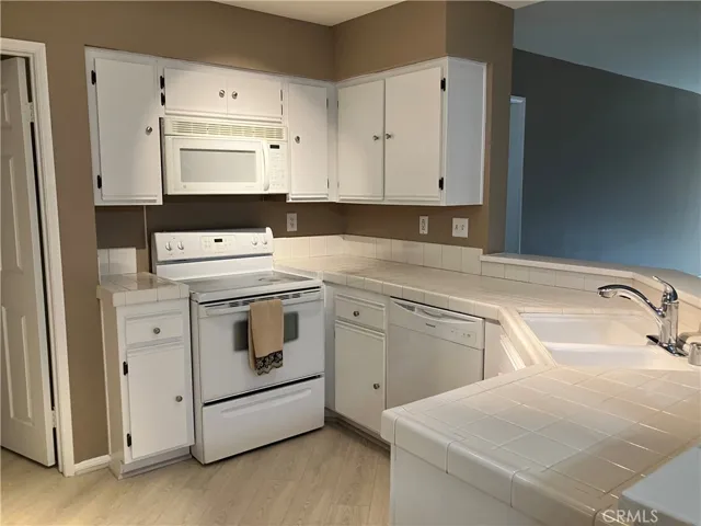 Kitchen, tile counter, microwave, induction stovetop and oven, Lined drawers and cabinets.