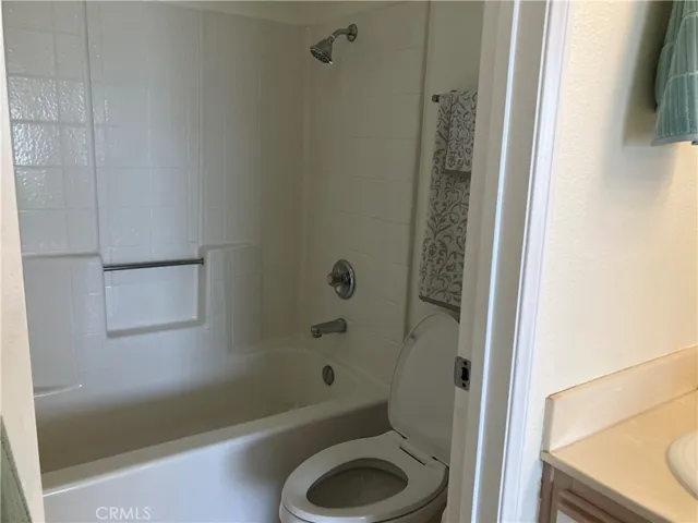 Primary Bedroom Bathtub and toilet area near double vanity sink.