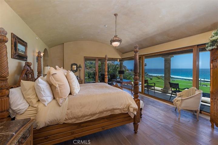 Primary Bedroom with natural white oak flooring. Curved barrel ceiling in hand troweled plaster.  His and Hers Bathrooms in the Primary Suite.  Home has 9 bathrooms.