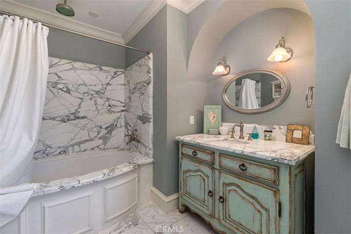 Guest Bathroom with slab marble walls and Perrin and Rowe fixtures.