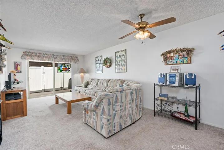Open floor plan with abundant natural light and ceiling fan.