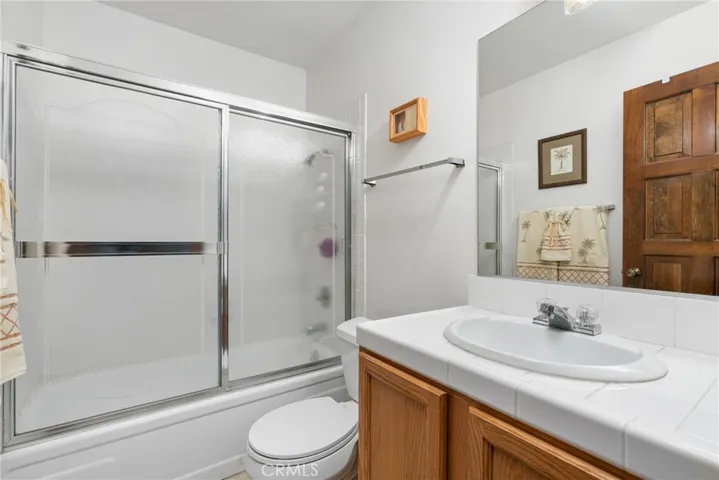 Hallway bathroom features enclosed tub, shower, and sink.