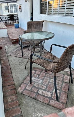 Small bistro table seats two in front of the dining room windows