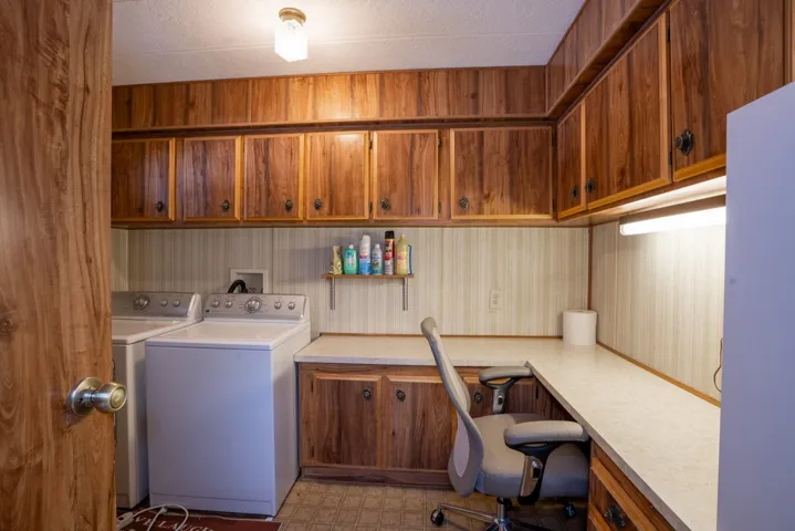 Large laundry room has washer, dryer and lots of counter and storage cabinets