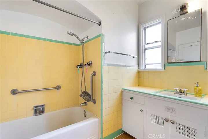 Stunning vintage bathroom with shower in tub.