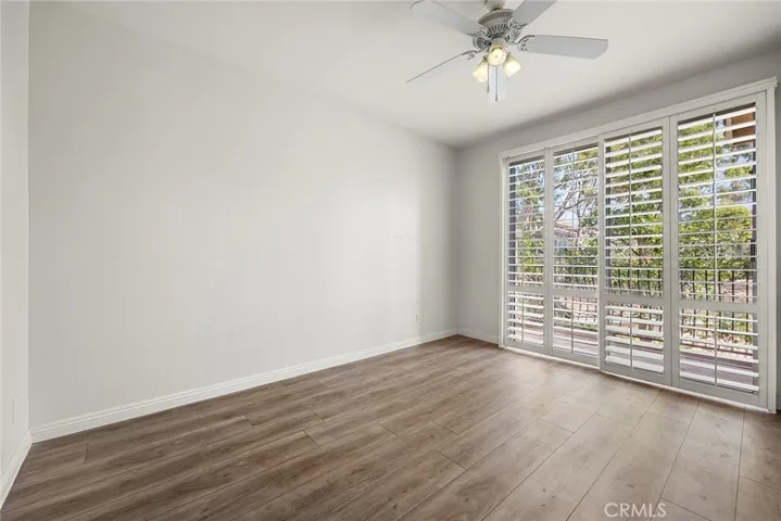 Primary Bedroom with ceiling fan and balcony.