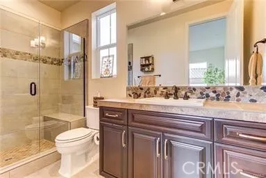 2nd Bathroom with walk-in-shower, seamless shower door, stone flooring and accents in shower and counter backsplash. Large farm sink.