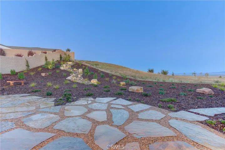 Just off the covered patio is the extended Flagstone patio and panoramic views of the backyard, dry creek bed and beyond