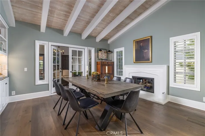 Formal dining room with fireplace, built is and French doors leading out to covered courtyard
