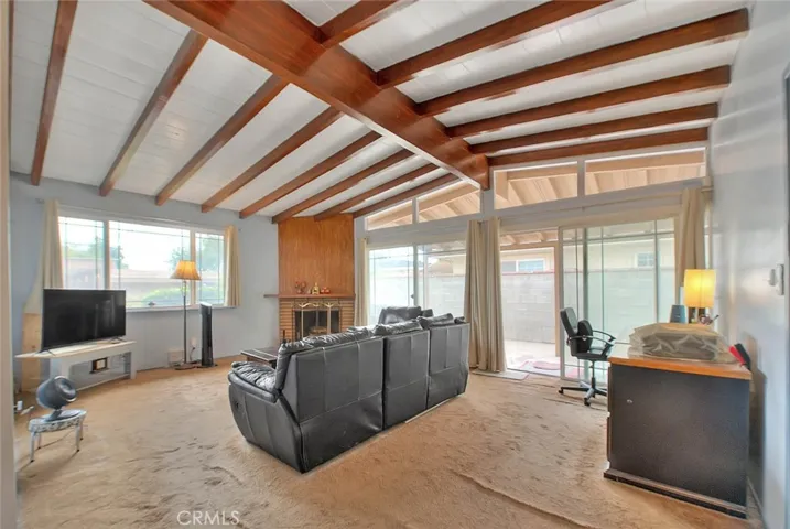 Spacious family room with wood beamed ceilings. Large picture windows allow for lots of natural lighting.