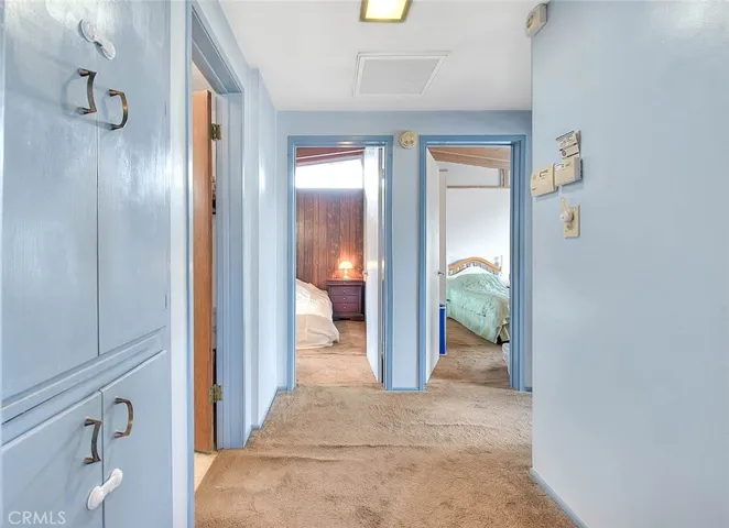 Hallway features linen storage cabinets