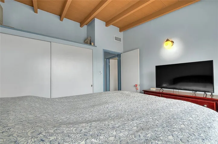 Large closet in with decorative shelf above in the primary bedroom.