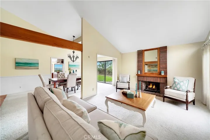 Formal living room has high ceilings and cozy brick fireplace.