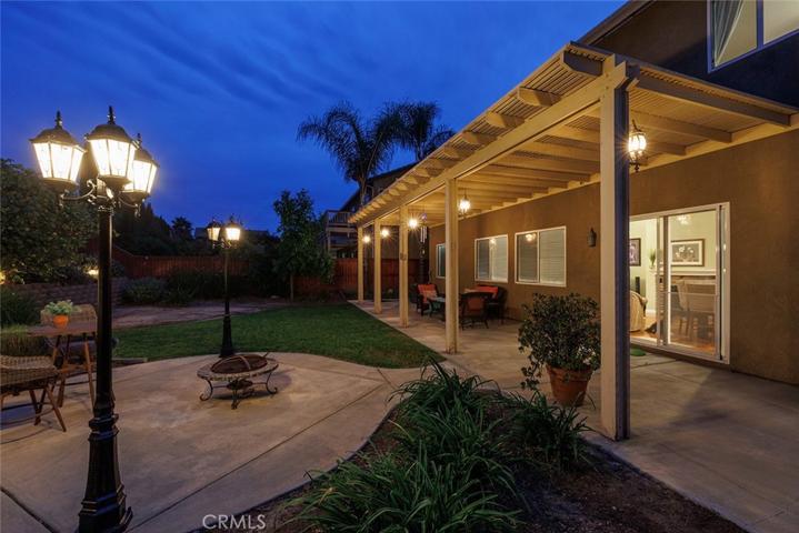Enchanting backyard with 3-head light posts flanking the fire pit area