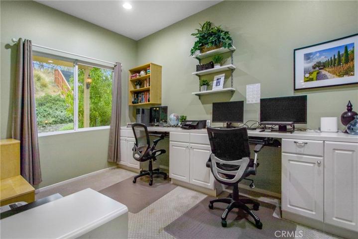 Large office space off of living room with multiple work stations