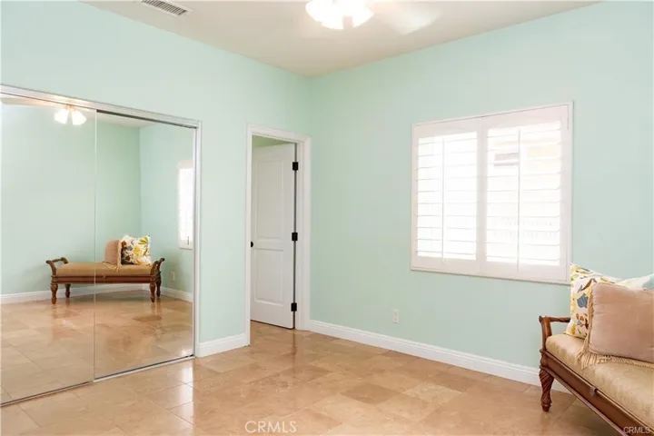 Master bedroom in bungalow with mirrored wardrobe doors and door into attached bathroom