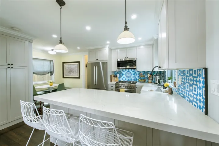 Beautiful design with quartz countertops, breakfast bar, stainless appliances, and gleaming cabinetry

