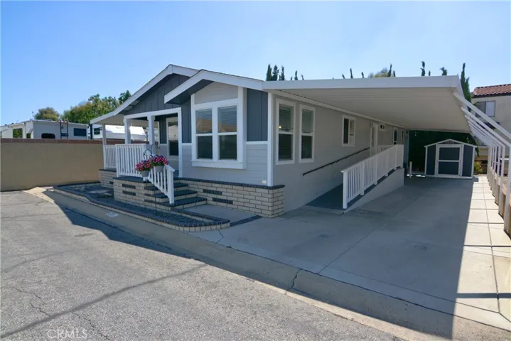 Front side view of carport, ramp and shed