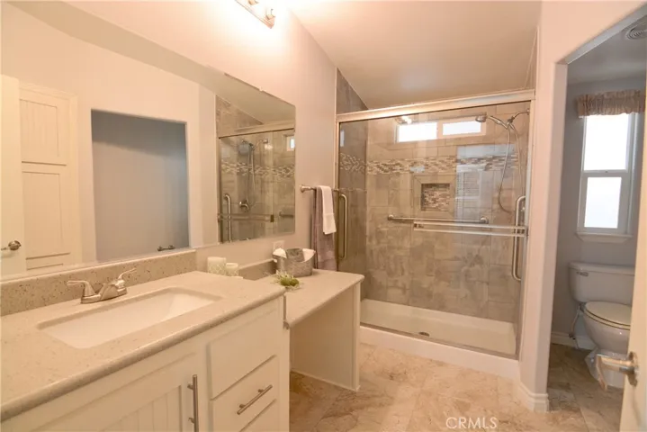Primary en-suite bath with walk in shower and vanity