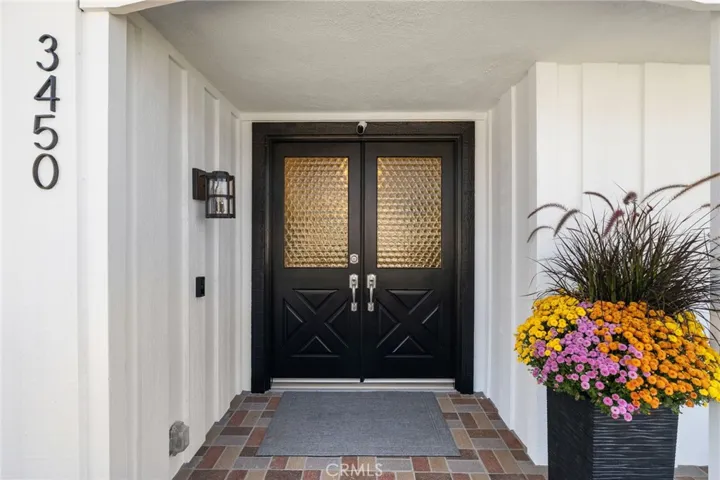 Double door entry on brick paved front porch.