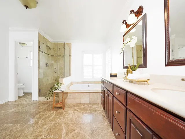 Generous master bath with large walk in shower and travertine finishes.