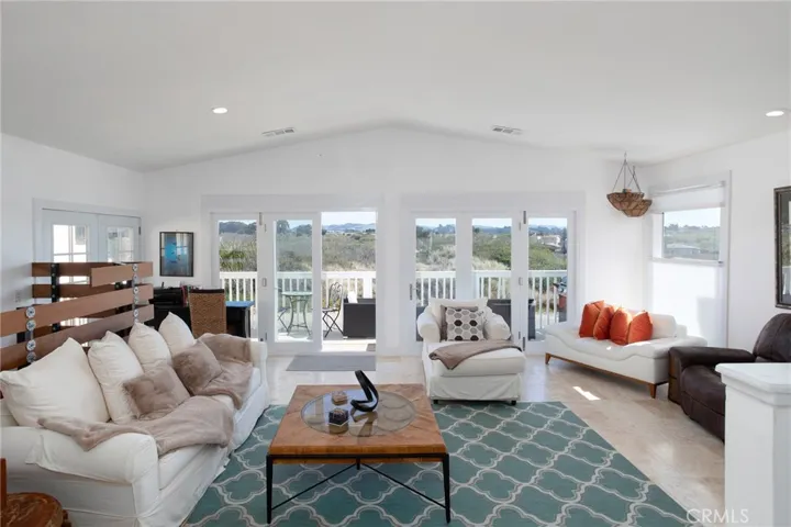 Great Room with fireplace and balcony. View toward the lagoon and green space.