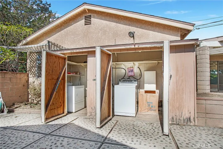 The laundry is located outside in a fully enclosed space and offers plenty of storage. The white box to the right of the photo is the laundry chute from the inside of the house!