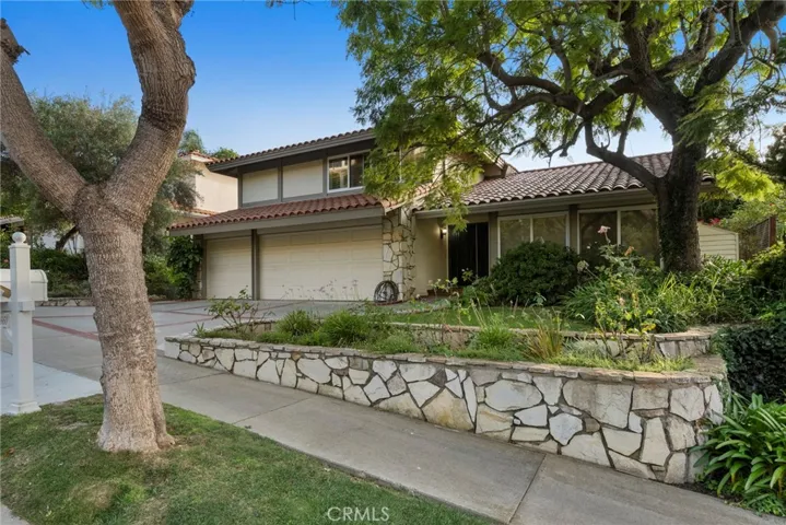 ...On a Tree Lined Street, this large Mediterranean Style Two Story Home awaits.