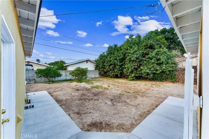 View of backyard from gate between to garage and home