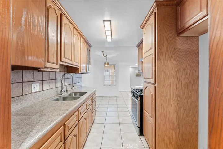 Traditional galley style kitchen with granite counters, stainless steel range and vent hood. opens up to living, dining and family rooms