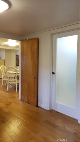Bedroom looking toward dining area. Shows glass door to bathroom.