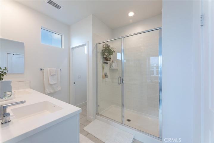 walk in shower with white subway tiles,  toilet future in room to the left in photo