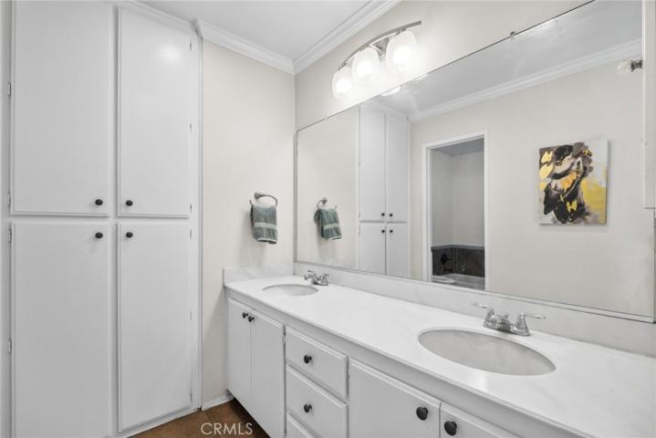 Master bath with dual sinks and linen cabinets, separate tub and large walk in shower
