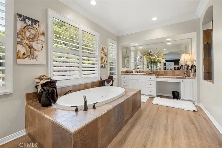 Pretty as a picture doesn't describe how this primary bathroom shows, it has two separate sinks and a separate vanity area, a jetted oversized tub, good sized walk-in shower with two waterfall shower heads and an additional held spray nozzle.Great size walk-in closet with a window for light.