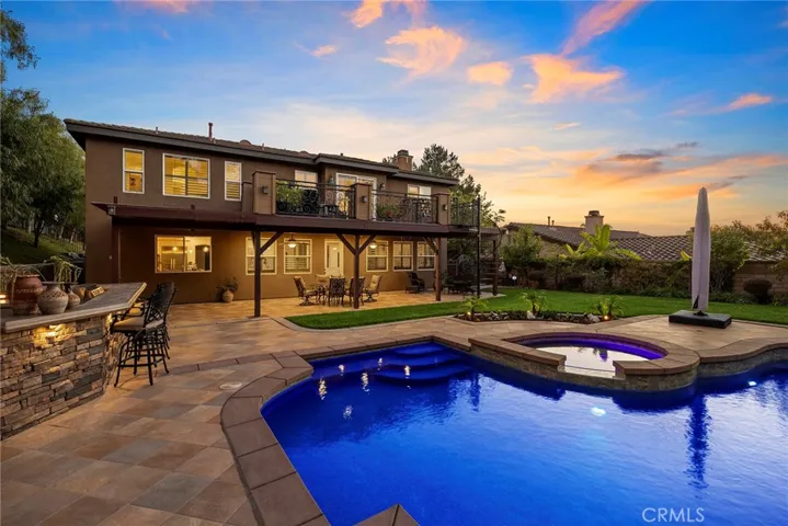 View of backyard showing patio and custom built deck with extensive amount of custom wrought iron and spiral staircase.