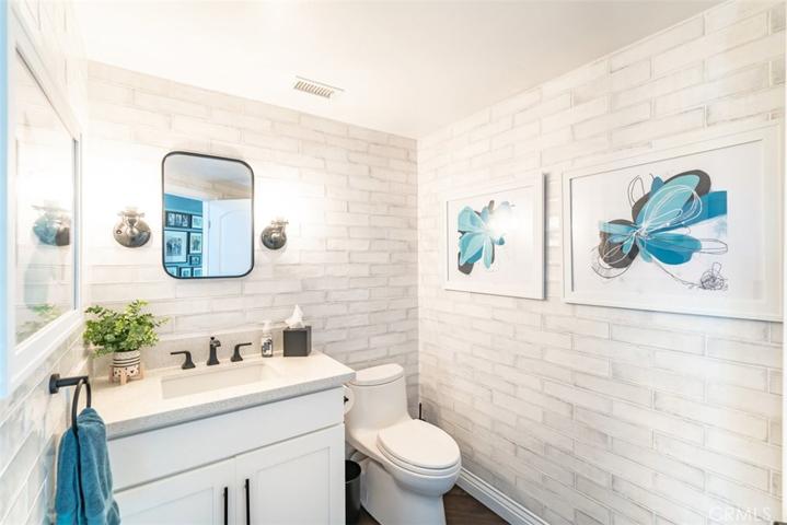 Main level powder room featuring floor to ceiling tile